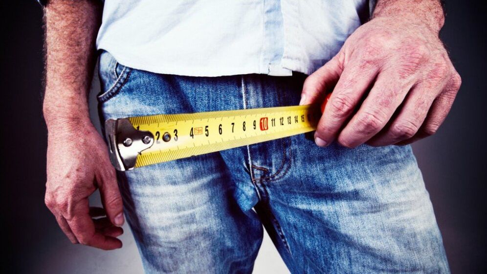 uomo che misura il pene dopo l'ingrandimento con il gel